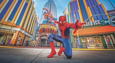 The Spider-Man character poses in front of the Spider-Man ride. Text: Universal's Islands of Adventure.