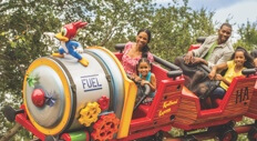 A family enjoys a ride on Woody Woodpecker's Nuthouse Coaster in Universal Studios Florida.
